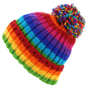 Handgestrickte Bommelmütze aus Wolle – gestreift in hellem Regenbogen
